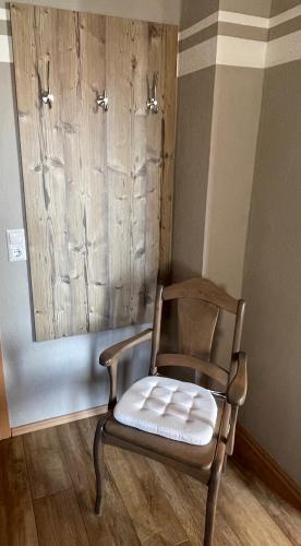 a chair sitting in a room with a mirror at Gästezimmer zum Sonnenhof in Zahna-Elster