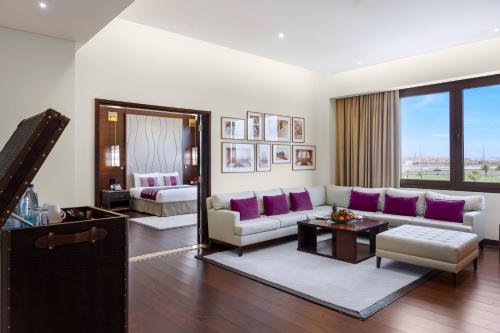 a living room with a couch and purple pillows at Grand Millennium Tabuk in Tabuk