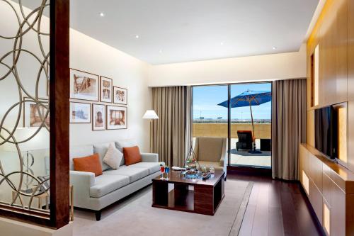 a living room with a white couch and a table at Grand Millennium Tabuk in Tabuk