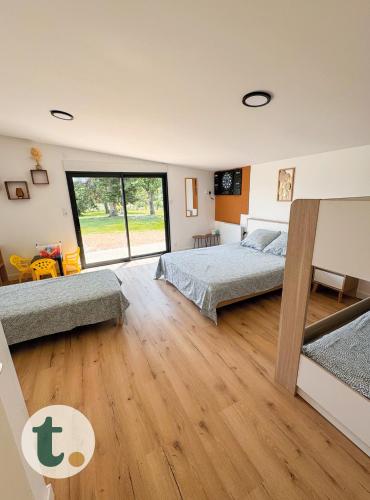 une chambre avec deux lits et une grande fenêtre dans l'établissement Tranquiloue - Gîte SPA Honorus - 5min du PuyduFou, aux Épesses