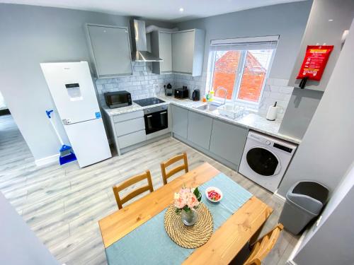 a kitchen with a table and chairs and a refrigerator at Large 1-Bedroom Flat, 5 Guest, London - F4 in London