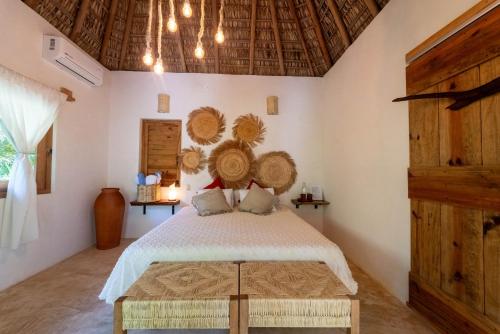 a bedroom with a bed with baskets on the wall at Casa Mariposa Beach Hotel in Tierra Blanca