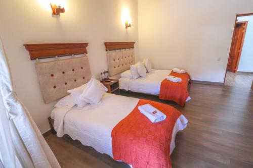 a hotel room with two beds in a room at Hotel las Palmas in Villa de Leyva