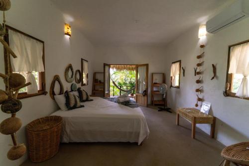 a bedroom with a large bed and a window at Casa Mariposa Beach Hotel in Tierra Blanca