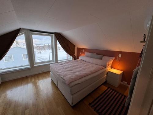 a bedroom with a bed and a large window at Agaton Apartment in Andenes