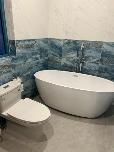 a bathroom with a white tub and a toilet at Biệt thự 3 phòng ngủ Novaworld Phan Thiết in Bình Sum
