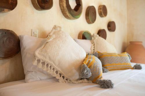a bed with pillows on it in a bedroom at Casa Mariposa Beach Hotel in Tierra Blanca