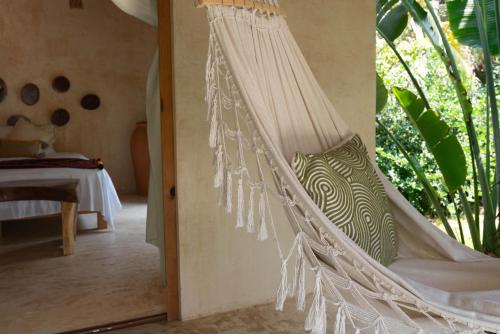 a hammock in a room with a bedroom at Casa Mariposa Beach Hotel in Tierra Blanca