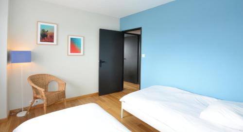 ヴィルールバンヌにあるAppart' Parcのベッドルーム1室(ベッド1台、椅子付)