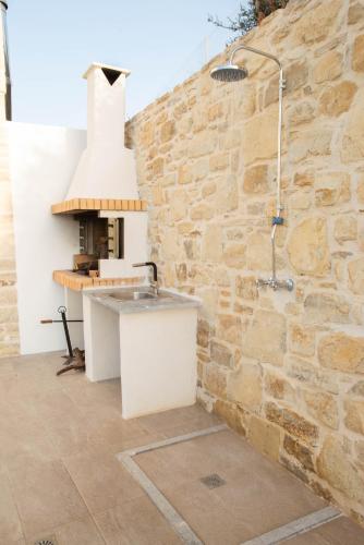 a kitchen with a stone wall and a stove at Villa Celine in Kamilari