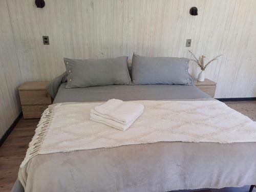 a bed with two towels on top of it at Casa Calma in Puerto Varas