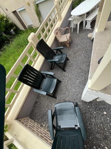 - un groupe de chaises et une table sur une terrasse couverte dans l'établissement Villa les Flots, à Ault