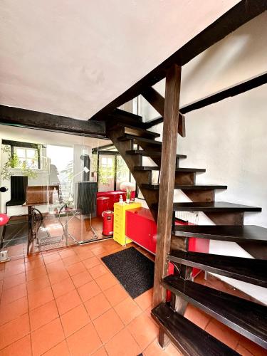 a living room with a wooden staircase in a house at Hexenhäuschen Dreieichenhain in Dreieich