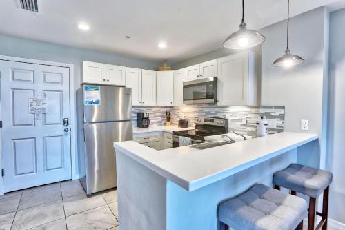 a kitchen with white cabinets and a stainless steel refrigerator at Madeira Bay Resort I 1504 in St Pete Beach