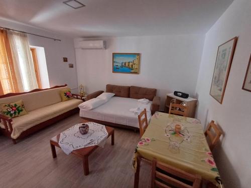 a living room with a couch and a table at Cozy Apartment in Drymades Village in Dhërmi