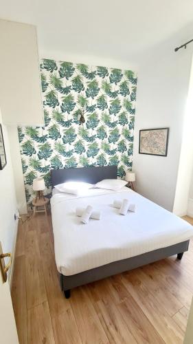 une chambre avec un lit blanc avec un mur vert dans l'établissement All new charming 1br hyper centre with balcony and AC, à Nice