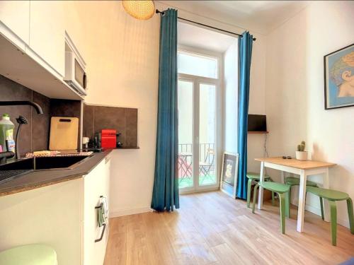 une cuisine avec une table et des chaises et une fenêtre dans l'établissement All new charming 1br hyper centre with balcony and AC, à Nice
