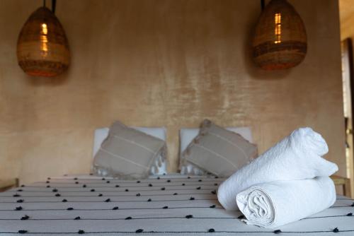 a bed with towels and pillows on top of it at Casa Mariposa Beach Hotel in Tierra Blanca