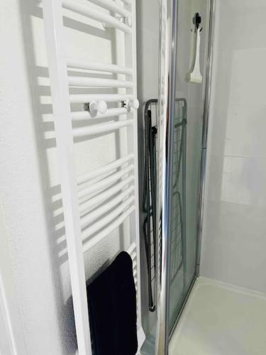 La salle de bains est pourvue d'une porte en verre et d'un miroir. dans l'établissement Le Petit Méridien, à Villers-sur-Mer