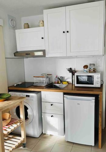 La cuisine est équipée de placards blancs, d'un four micro-ondes et d'un lave-vaisselle. dans l'établissement Le Petit Méridien, à Villers-sur-Mer