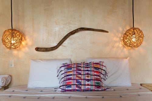 a bedroom with a bed with two lamps and two pillows at Casa Mariposa Beach Hotel in Tierra Blanca