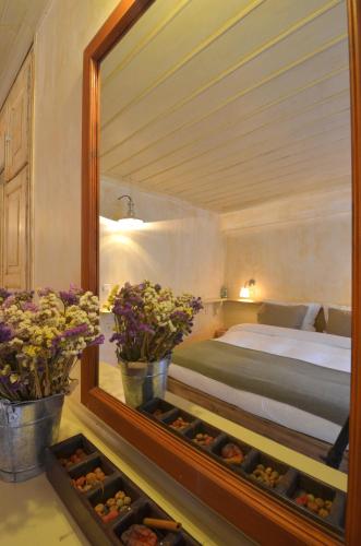 a bedroom with a bed and a mirror and flowers at Papaevangelou Hotel in Papigko