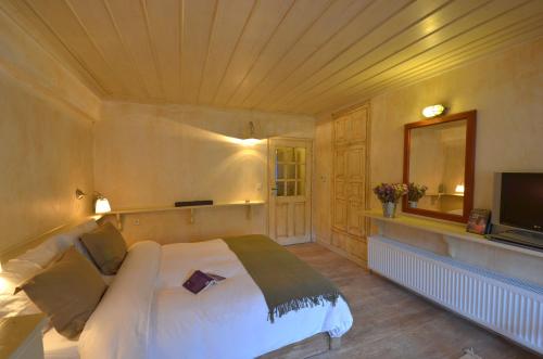 a bedroom with a white bed and a television at Papaevangelou Hotel in Papigko