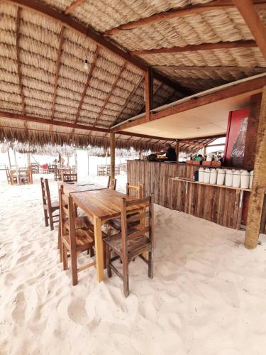a wooden table and chairs on the beach at Jangaloa in Jijoca de Jericoacoara