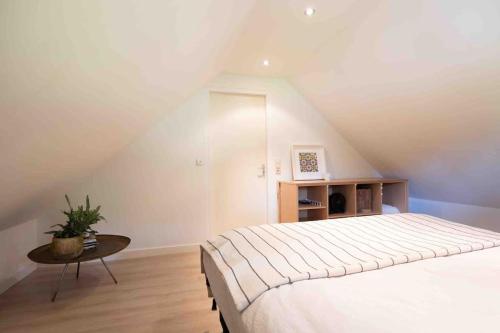 a bedroom with a large bed and a table at Gastenverblijf Studio 22 - woonboerderij in Haaren