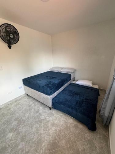 two beds in a room with blue sheets at Casa San Miguel 101 in Medellín