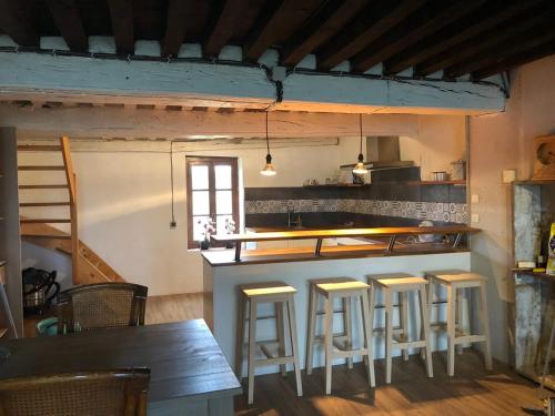 une cuisine avec un comptoir et des tabourets dans une pièce dans l'établissement Maison Bonheur Resort Bousset, à Chiddes