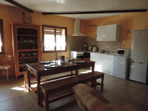 Il comprend une cuisine avec une table en bois et des appareils électroménagers blancs. dans l'établissement Gîtes Le 
