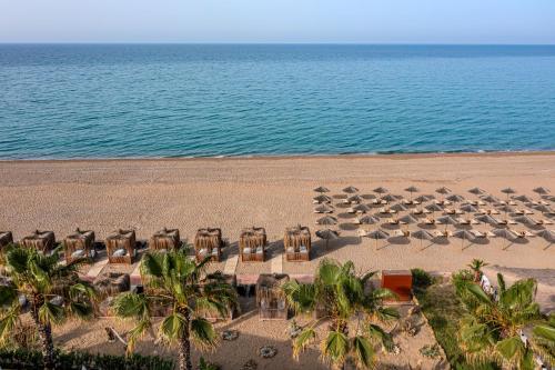 an aerial view of a beach with chairs and the ocean at Adora Calma Beach Hotel Adults Only in Kızılot