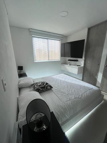 a bedroom with a large bed and a television at Luxor apartment in Medellín