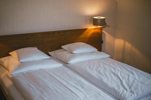 a large white bed with two pillows on it at Pension Relish in Rajecké Teplice
