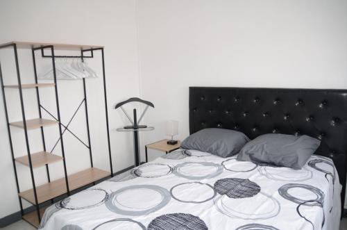 une chambre avec un grand lit avec une tête de lit noire dans l'établissement APPARTEMENT T3 LUXUEUX dans RESIDENCE, à Tarbes