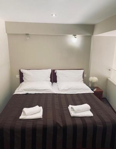 a large bed with two white towels on it at Božikovina Beach Rooms in Podstrana