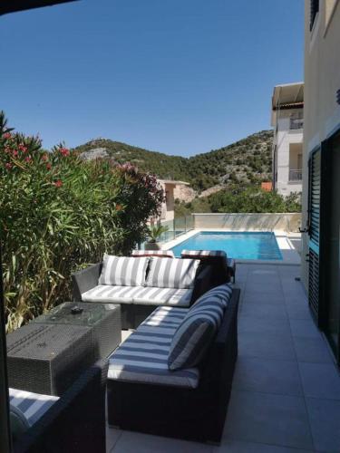 a patio with two couches and a swimming pool at Villa royale with shared pool in Hvar