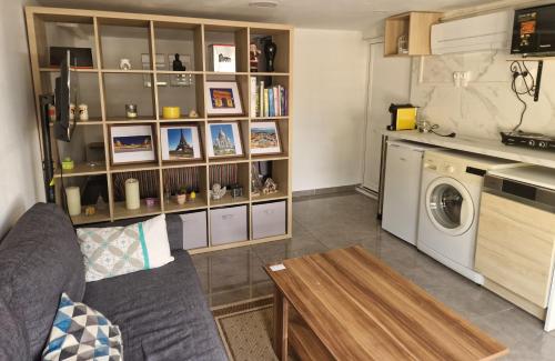 un salon avec un canapé et une machine à laver dans l'établissement L'auberge de Sucy - Studio Climatisé, à Sucy-en-Brie