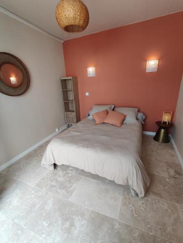 une chambre avec un grand lit aux murs rouges dans l'établissement Chambre cabane de charme, terrasse et spa privé, à Valras-Plage