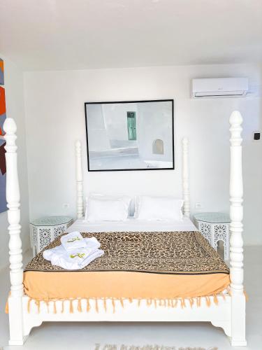 a bedroom with a white bed with a mirror above it at Dar Fen Luxery House in Houmt Souk