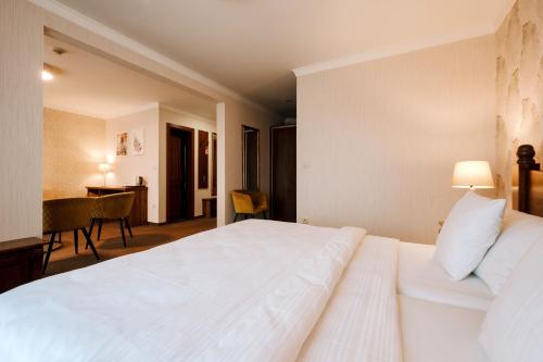a bedroom with a large white bed and a desk at Pension Relish in Rajecké Teplice