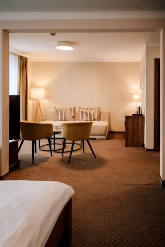 a hotel room with a couch and a table and chairs at Pension Relish in Rajecké Teplice
