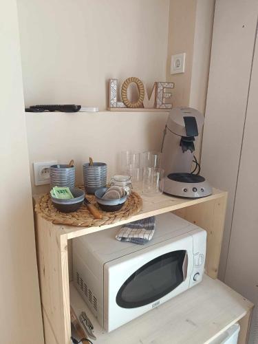 un micro-ondes sur une étagère en bois avec un mixeur dans l'établissement Chambre cabane de charme, terrasse et spa privé, à Valras-Plage