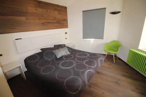 a bedroom with a large bed and a green chair at MIRUTT by Keyhole Selection in Castelmezzano