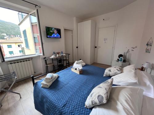 a bedroom with two beds and a tv on the wall at Affittacamere Il Veliero in Levanto