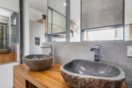 La salle de bains est pourvue d'un grand lavabo en pierre sur un comptoir en bois. dans l'établissement Heliopolis K 116 