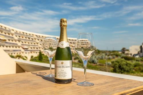 - une bouteille de champagne et 2 verres à vin sur une table dans l'établissement Heliopolis K 116 