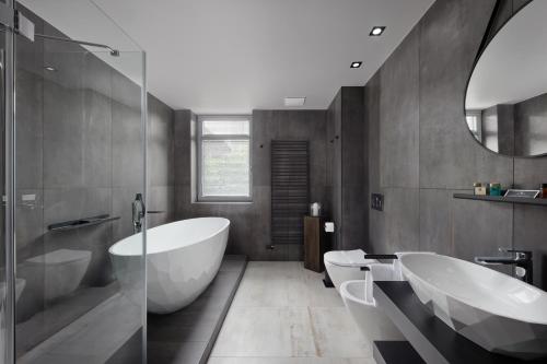 a bathroom with two sinks and a tub and a mirror at Spa Hotel Felicitas in Poděbrady