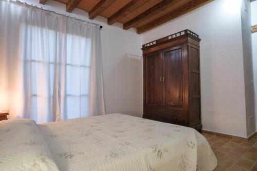 a bedroom with a bed and a wooden cabinet at Agriturismo Niccoland in Grosseto